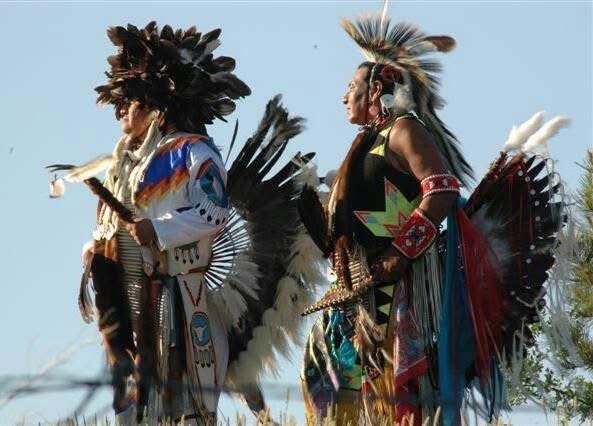 Indigenous community members in traditional regalia standing together